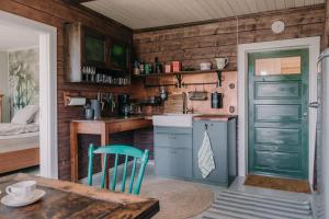 a kitchen with a table and a green door at Cozy forest cabin with wood-fired sauna in Naantali