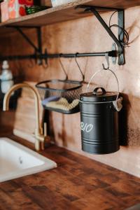 a black bucket on a shelf next to a sink at Cozy forest cabin with wood-fired sauna in Naantali +36 photos