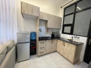 a small kitchen with a refrigerator and a sink at Tulia, Anchor in Ruaka
