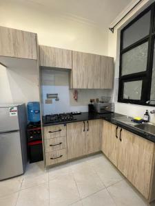 a kitchen with wooden cabinets and a refrigerator at Tulia, Anchor in Ruaka +1 photo