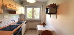 a small kitchen with a sink and a window at Gästehaus Seeblick in Langenargen +57 photos