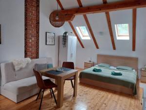 a bedroom with a bed and a couch and a table at Studioapartment Taiga in Grabovac