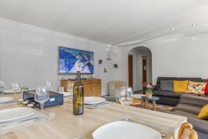 a living room with a table with wine glasses at Logement spacieux et charmant in Nendaz