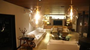 a living room with white couches and chandeliers at Casa a jabuticabeira in Avaré