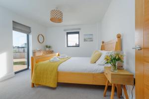 a bedroom with a bed and a vase of flowers on a table at Silvermere in Warmwell