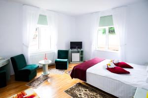 a bedroom with a bed and two chairs and a television at Clermont Sinaia in Sinaia