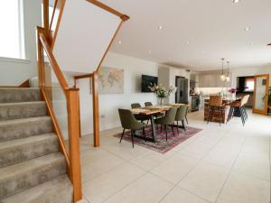 a kitchen and dining room with stairs and a table and chairs at Balcarry Barn in Newton Stewart
