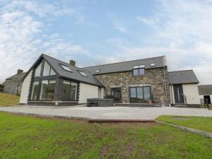 a stone house with a black roof at Balcarry Barn in Newton Stewart