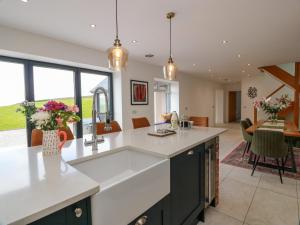 a kitchen with white countertops and a living room at Balcarry Barn in Newton Stewart