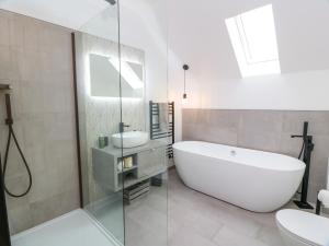 a bathroom with a tub and a toilet and a sink at Balcarry Barn in Newton Stewart +35 photos