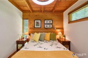a bedroom with a large bed with two night stands at Le Boreal in Pohénégamook