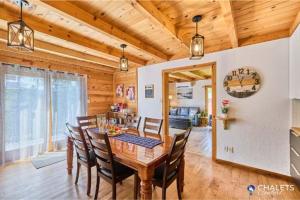 a wooden dining room with a table and chairs at Le Boreal in Pohénégamook