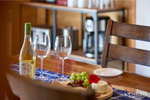 a table with two wine glasses and a bottle of wine at Le Boreal in Pohénégamook