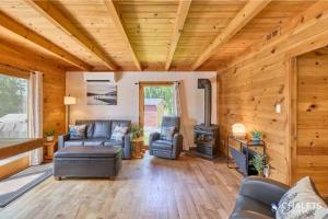 a living room with a couch and a stove at Le Boreal in Pohénégamook