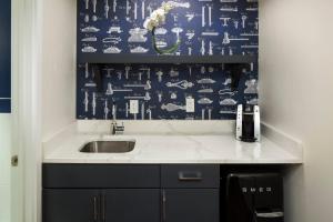 a bathroom with a sink and a blue and white wallpaper at Hotel Indigo Boston Garden by IHG in Boston +80 photos
