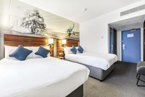 a hotel room with two beds and a blue door at Heeton Concept Hotel - City Centre Liverpool in Liverpool +43 photos