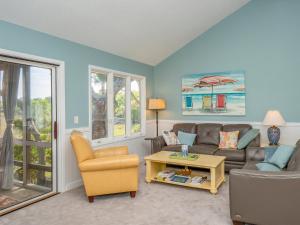 a living room with a couch and a table at 1228 Creekwatch Villa in Seabrook Island