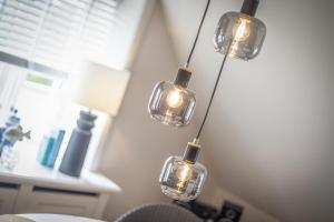 a group of four lights hanging from a wall at Strandkrabbe in Keitum +19 photos