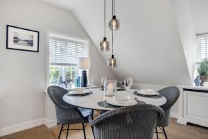 a dining room with a white table and chairs at Strandkrabbe in Keitum
