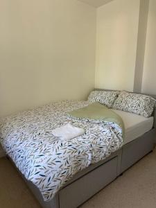 a bed in a room with a bedspread on it at Cosy House in Reading +3 photos