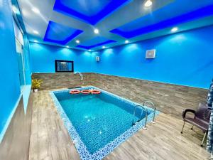 a swimming pool in a room with blue ceilings at شاليهات سكون الغروب in Taif +4 photos