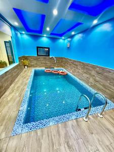 a large swimming pool in a room with a blue ceiling at شاليهات سكون الغروب in Taif