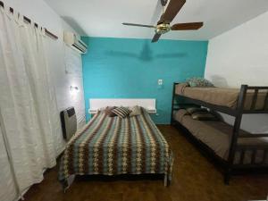 a room with two bunk beds and a ceiling fan at Apart Hotel RioSol in Concepción del Uruguay