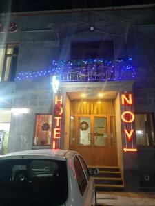 a car parked in front of a building with a neon sign at Noy in Goris