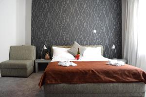 a bedroom with a large bed with a chair and a pillow at Hotel Kralj in Vrnjačka Banja +51 photos