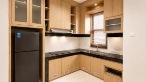 a kitchen with wooden cabinets and a refrigerator at SleepRest @ The Home Shoutlink in Nagoya
