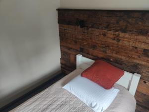 a bed with a red and white pillow on it at Jaunkemeri in Debeskrogs