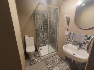 a bathroom with a shower and a toilet and a sink at Jaunkemeri in Debeskrogs