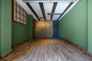 an empty room with green walls and wooden floors at Bed&Dreams con Jacuzzi in Bergamo