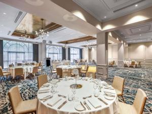 a banquet room with tables and chairs and a stage at The Playford Adelaide - MGallery in Adelaide