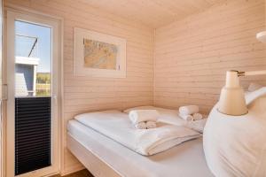 a small room with a bed with towels on it at Knobis DreamPlace in Heiligenhafen