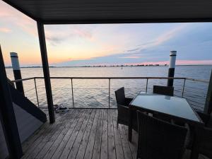a table and chairs on the deck of a boat at Knobis DreamPlace in Heiligenhafen