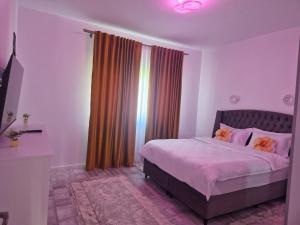 a bedroom with a bed with pink sheets and a window at Apartamente 2026 in Fălticeni