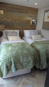 two beds sitting next to each other in a bedroom at Harestanes Hideaway in Kirkintilloch