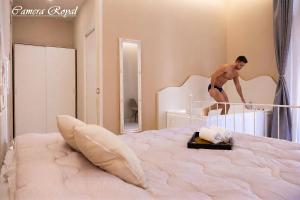 a man standing on top of a bed at Dharma Luxury Room in La Spezia