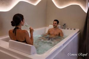 a man and a woman sitting in a bath tub at Dharma Luxury Room in La Spezia