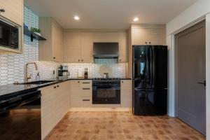a kitchen with a black refrigerator and wooden cabinets at High-end Lakefront Condo B6 Wapato Point Chelan in Manson