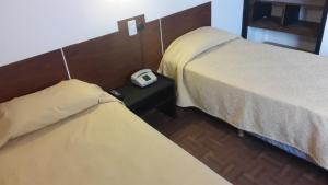 Habitación con 2 camas y reloj en una mesa en Hotel Regidor en San Luis