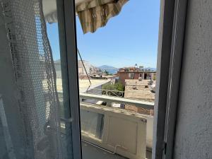 an open window with a view of a city at Old Saranda Apartments in Sarandë