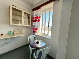 a room with a table and chairs and a window at Old Saranda Apartments in Sarandë
