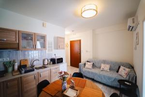a kitchen and living room with a couch and a table at Zoe Apartment Port View Β in Rafina