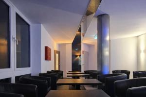 a waiting room with tables and chairs at Check-Inn Hotel - free parking in Offenbach