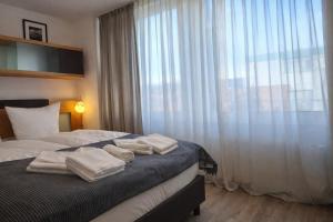 a bedroom with a bed with towels on it at Check-Inn Hotel - free parking in Offenbach