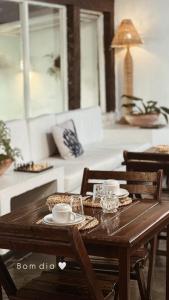 a wooden table with cups and plates on it at Peixe Crew Centro in Búzios