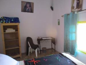 a bedroom with a desk and a chair and a bed at Le Retour au calme Maison d'hôtes in Tinerhir