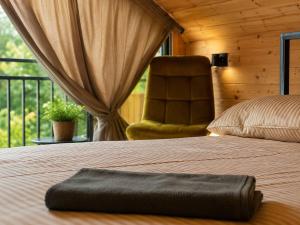 a bedroom with a bed with a chair and a window at NorWay1 in Ijevan